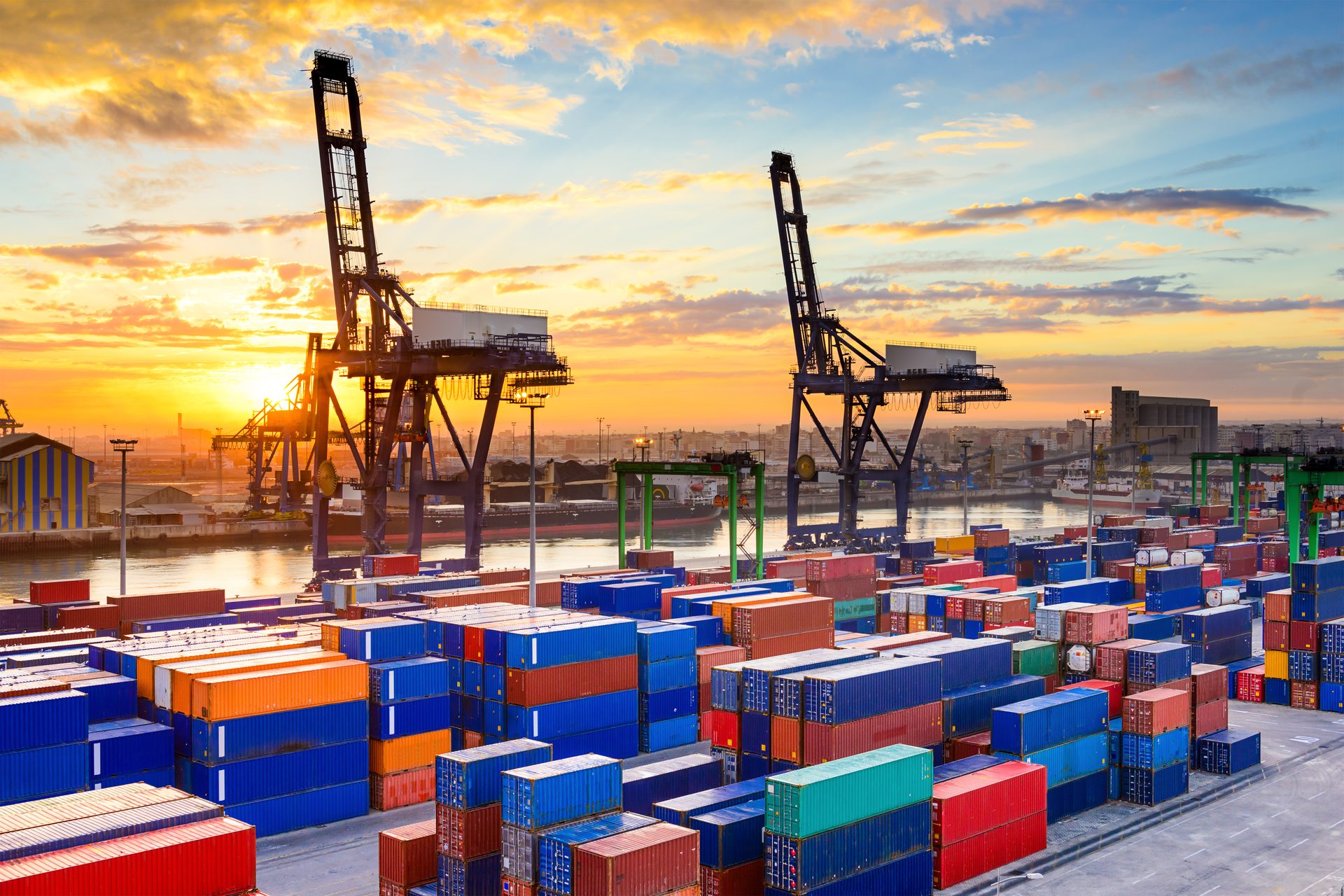 Container port at dawn with cranes loading cargo ships